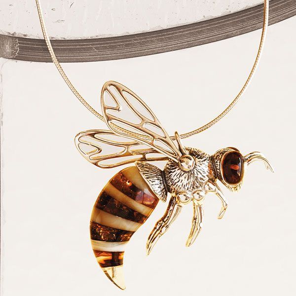 a necklace with a bee pendant hanging from it's side