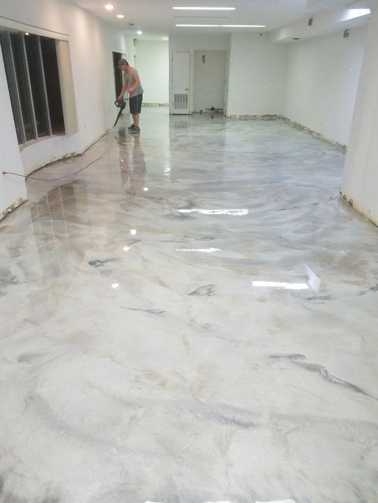 a man is cleaning the floor in an empty room with white walls and marble floors