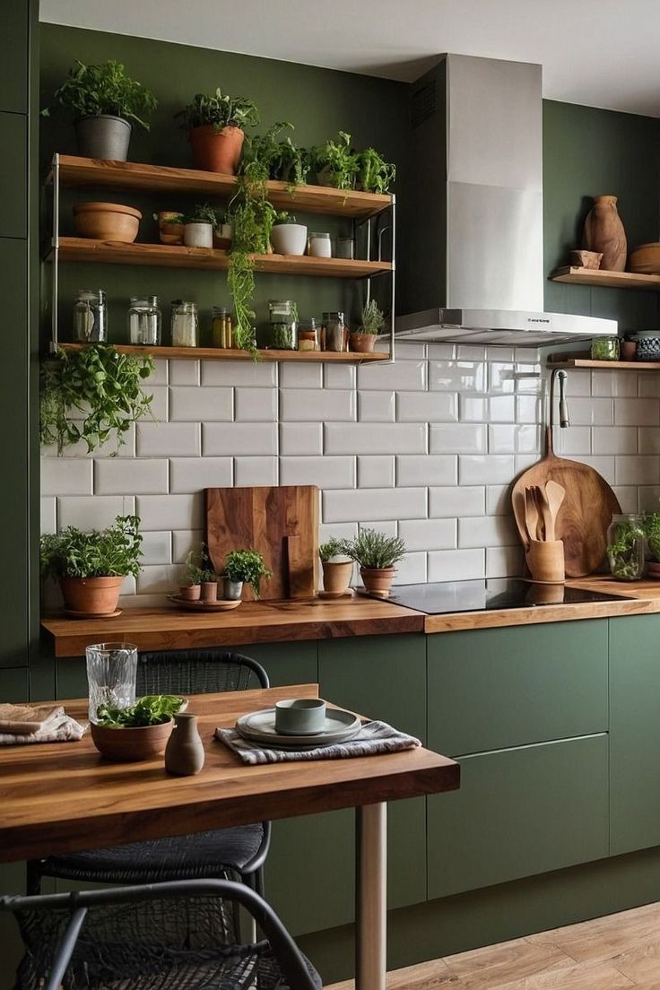 a kitchen filled with lots of green cupboards and counter top space next to a wooden table