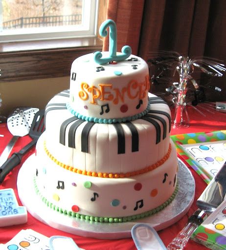 a three tiered cake with musical notes on it and the number one on top