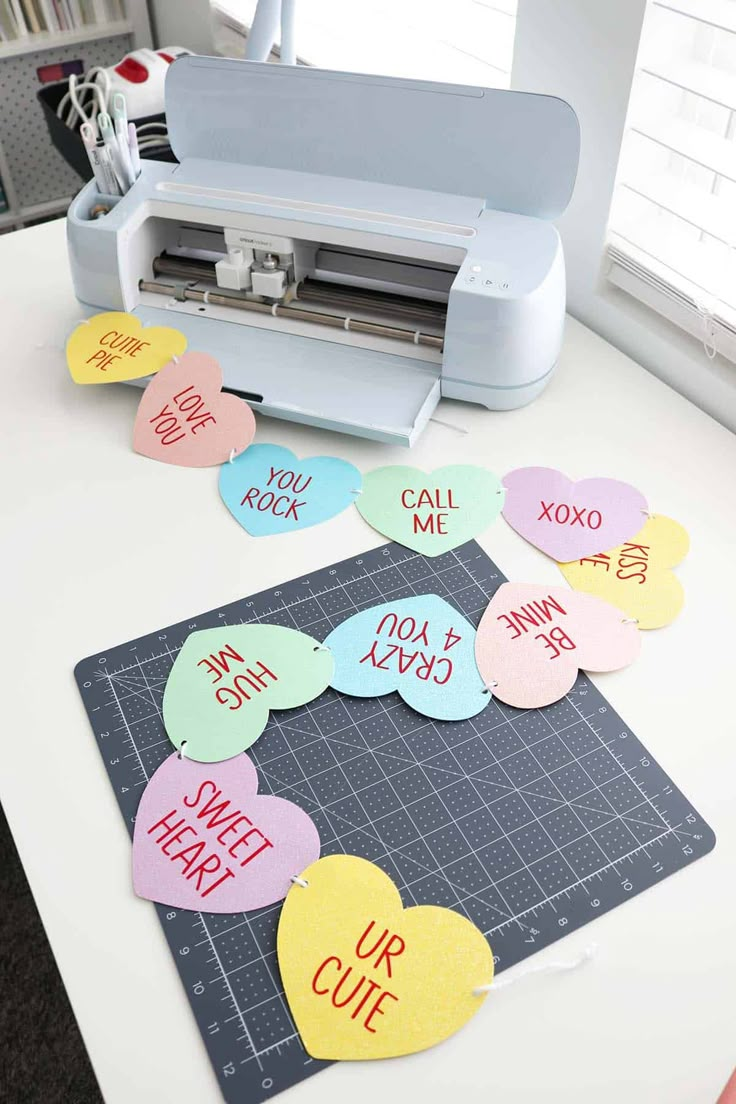 a cutting mat with cut out hearts on it next to a cricut machine