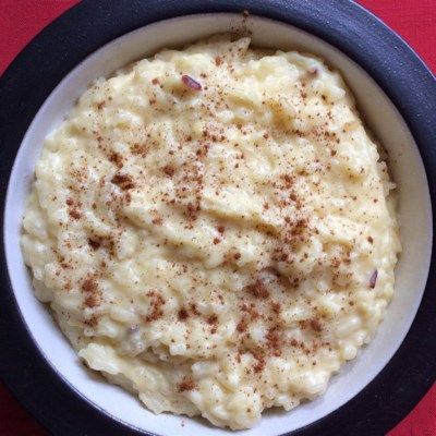 a bowl filled with mashed potatoes on top of a red table