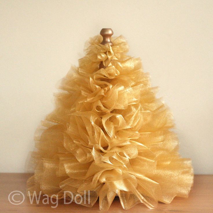 a small yellow christmas tree sitting on top of a wooden table