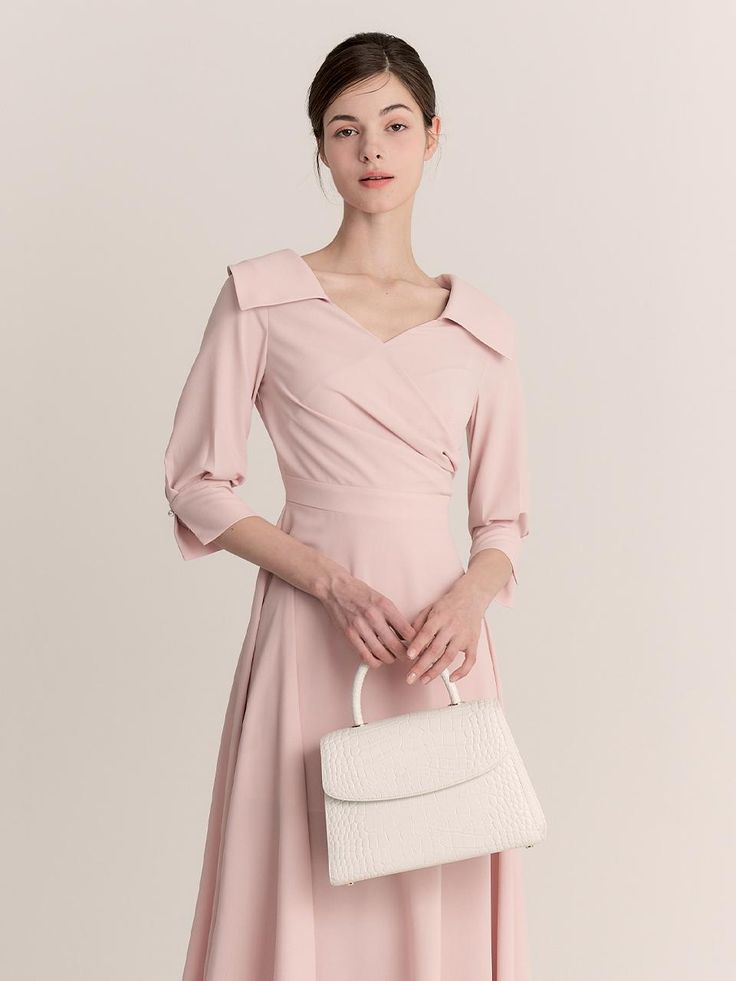 The Diamant Dress is a beautifully structured piece that exudes elegance and sophistication. This mid-length dress comes in a soft blush pink hue and features a unique, asymmetrical collar that adds a modern twist to the classic silhouette. The tailored bodice and A-line skirt provide a flattering fit, while the long sleeves with subtle cuff details enhance the dress's formal appeal. - The Diamant Dress is characterized by its distinct asymmetrical collar, offering a contemporary edge to a traditional design.- Crafted from a smooth, high-quality fabric, the dress drapes elegantly and maintains its shape throughout wear.- Its cinched waist and flowing A-line skirt accentuate the natural waistline and create a graceful, feminine profile.- Suitable for formal events and sophisticated gat Elegant Asymmetrical Beige Dress, Elegant Asymmetrical A-line Wedding Dress, Beige Evening Dress With Asymmetrical Neckline, Elegant Asymmetrical Wedding Dress For Spring, Feminine Fitted Asymmetrical Evening Dress, Elegant Fitted Asymmetrical A-line Dress, Elegant Fitted A-line Asymmetrical Dress, Feminine A-line Midi Dress For Evening, Pink Asymmetrical Dress For Evening With Asymmetrical Neckline