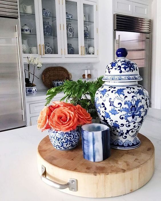 a blue and white vase sitting on top of a wooden cutting board in a kitchen