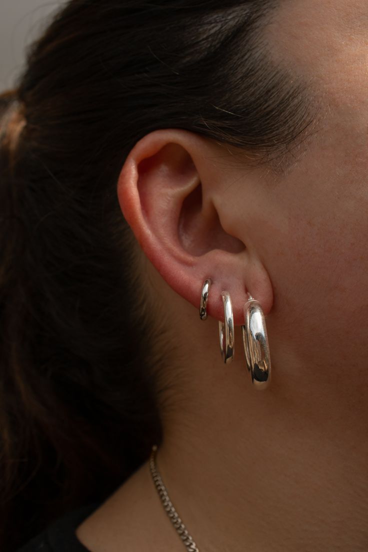 a close up of a person wearing some kind of silver earring on their left ear