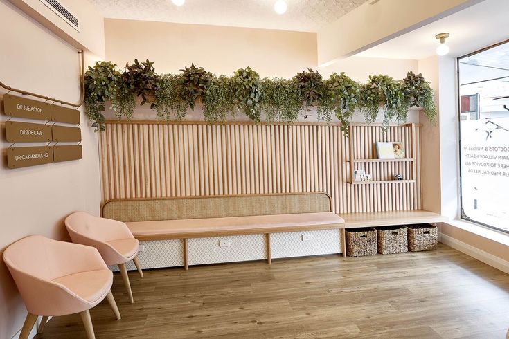 a room with two chairs and a bench in front of a wall that has plants growing on it