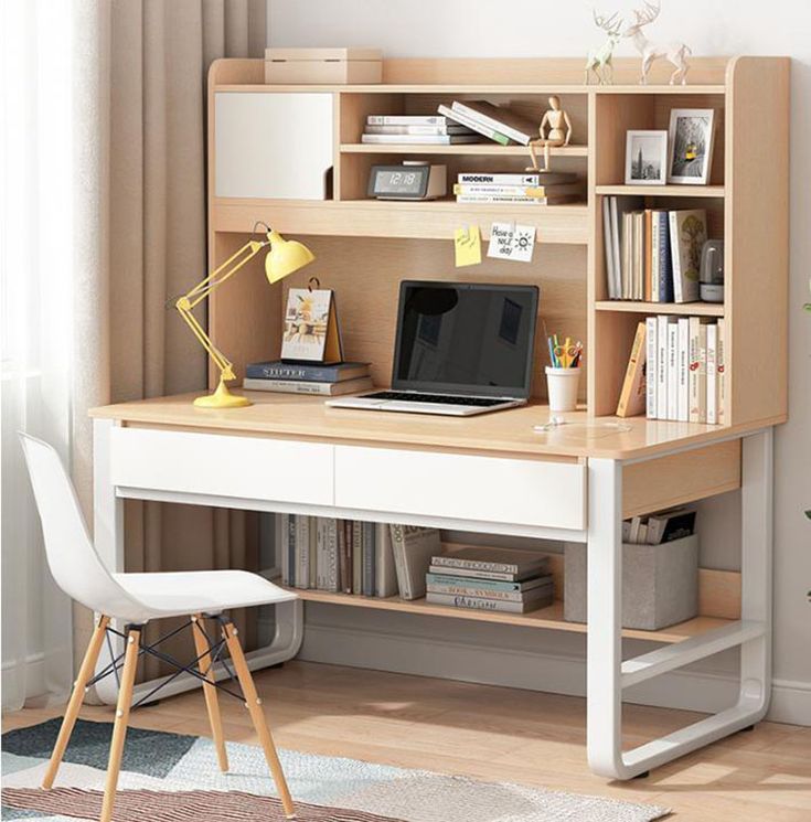 a computer desk with a laptop on top of it next to a chair and potted plant