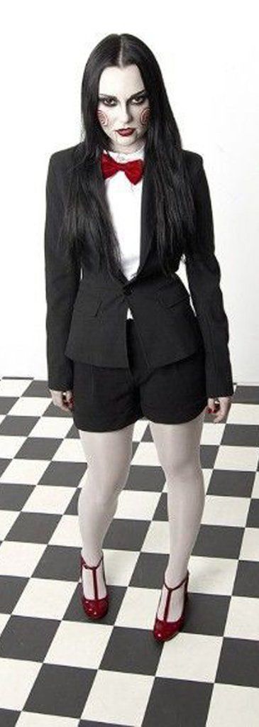 a woman in a suit and red shoes standing on a checkered floor