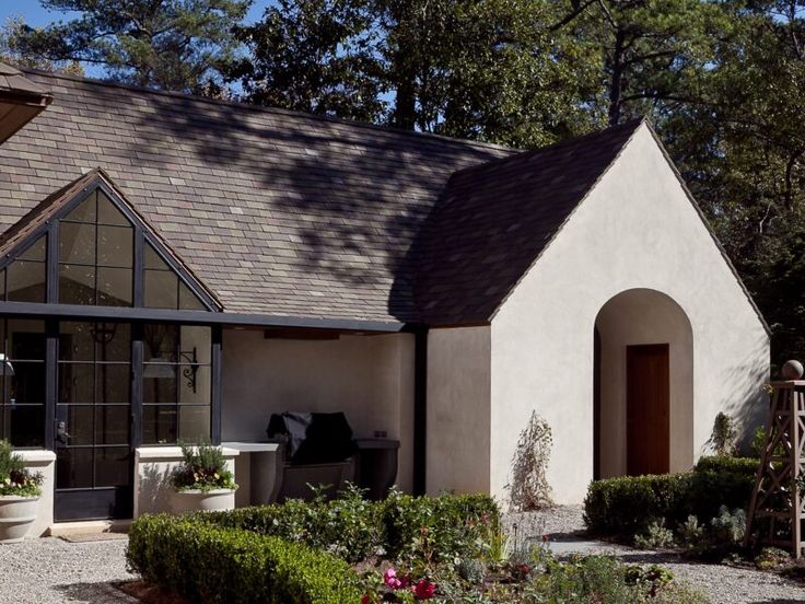 a white house with plants and flowers in the front yard