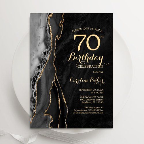 a black and gold 70th birthday party card on a plate with a white ribbon around it