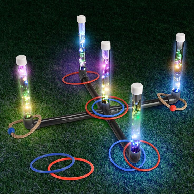 an assortment of different colored lights on top of a green grass covered field with rings around them