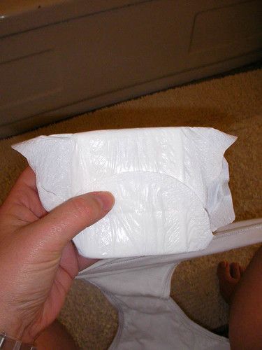 a person holding a piece of toilet paper in their left hand and pointing at it