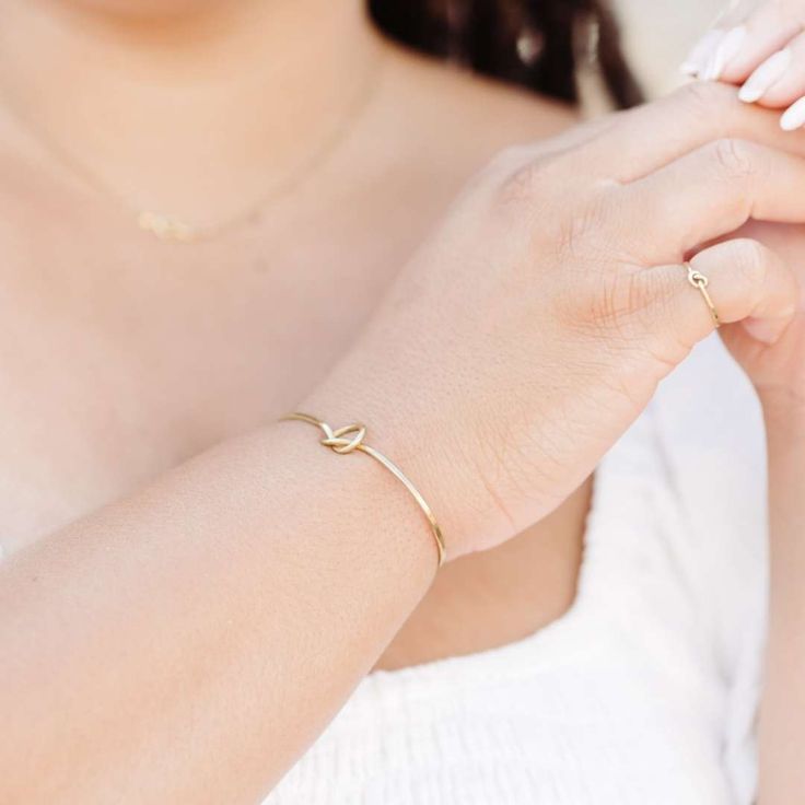 The Forget-Me-Knot Cuff is a simple handmade cuff that features a high-polish finish and time-honored knot detail that makes a greater statement piece. The adjustable cuff is made to go with any look and each knot is unique and carefully handmade by our artisan survivors. We love pairing this cuff with the knot studs, necklace, and knot ring. This best selling cuff is part of the “Hope Line” which consists of introductory pieces made by our new artisans, and it tells a powerful story of fresh be Modern Twist Bangle As Gift, Adjustable Modern Twist Bangle, Adjustable Bangle With A Modern Twist For Gifts, Adjustable Bangle With A Modern Twist As A Gift, Modern Twist Adjustable Bangle As A Gift, Elegant Adjustable Cuff Bracelet For Friendship, Holistic Care, Knot Studs, Knot Ring