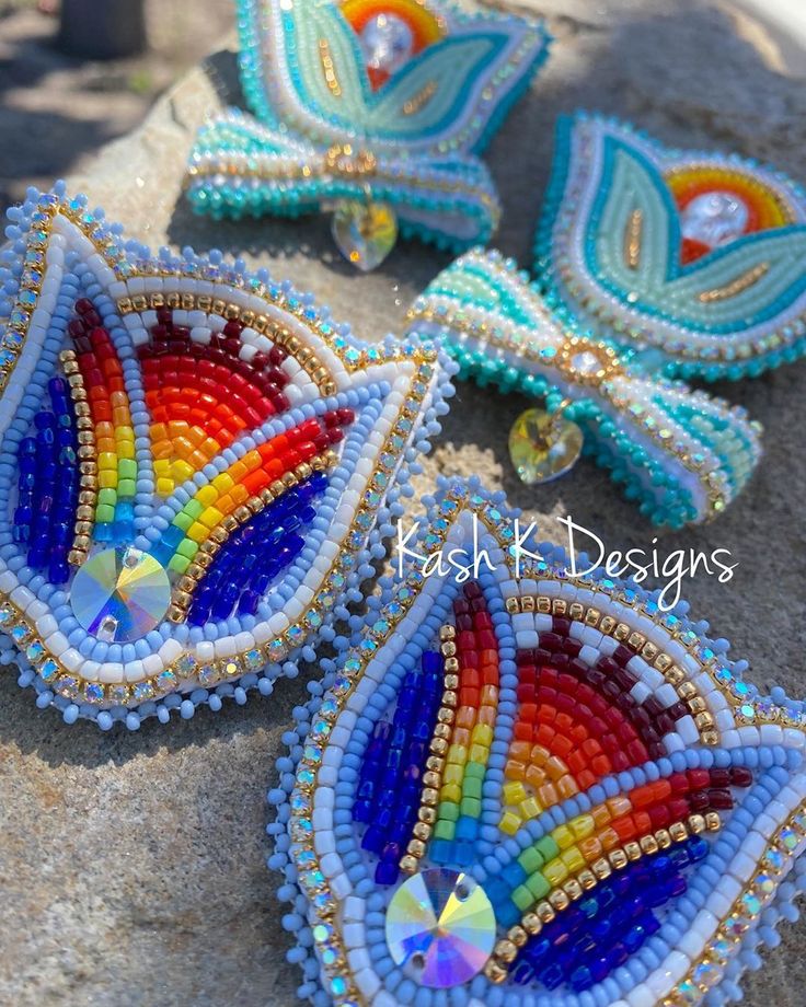 three colorful beaded earrings sitting on top of a rock