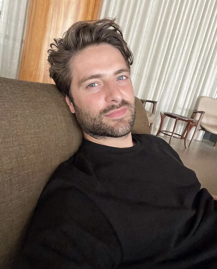 a man sitting on top of a brown couch