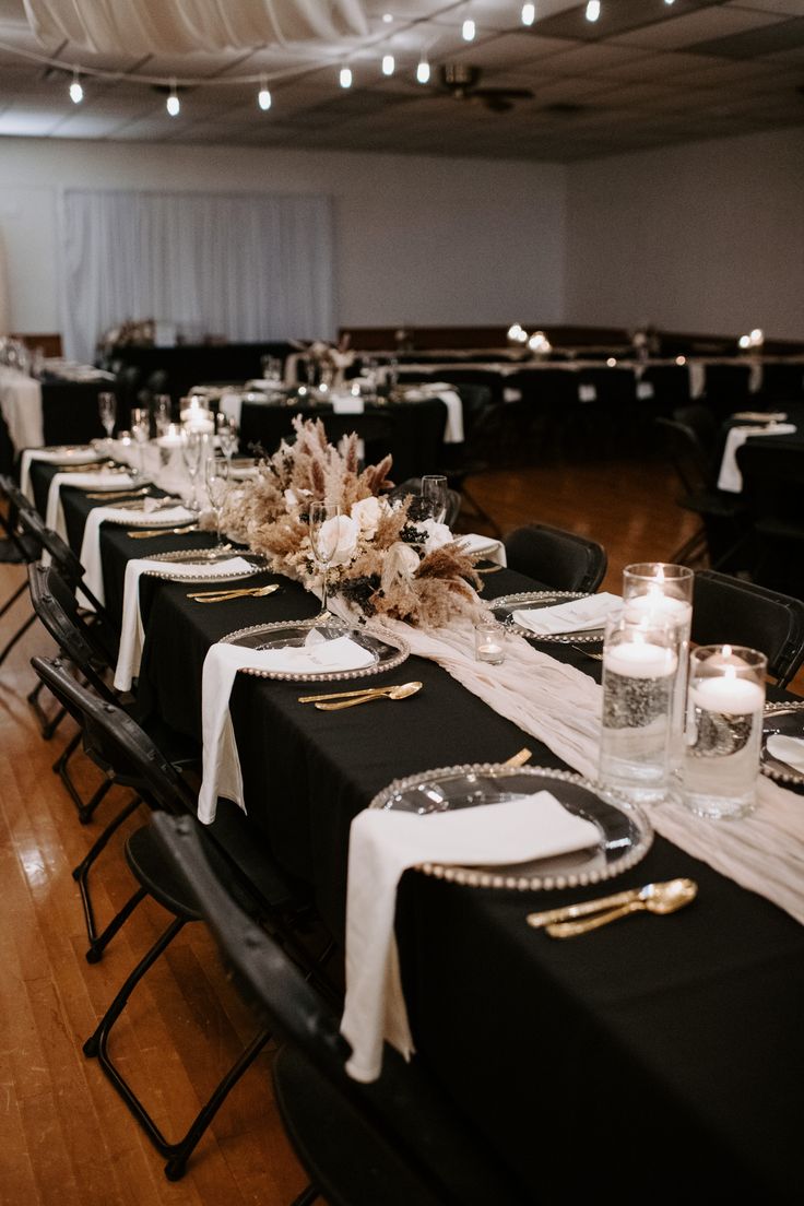 the tables are set with black linens and white tablecloths, gold trimmed centerpieces