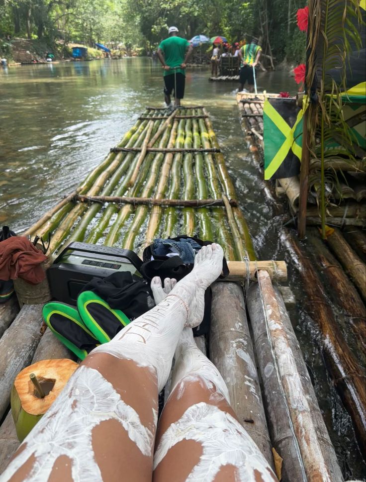 a person laying on top of a wooden raft in the water