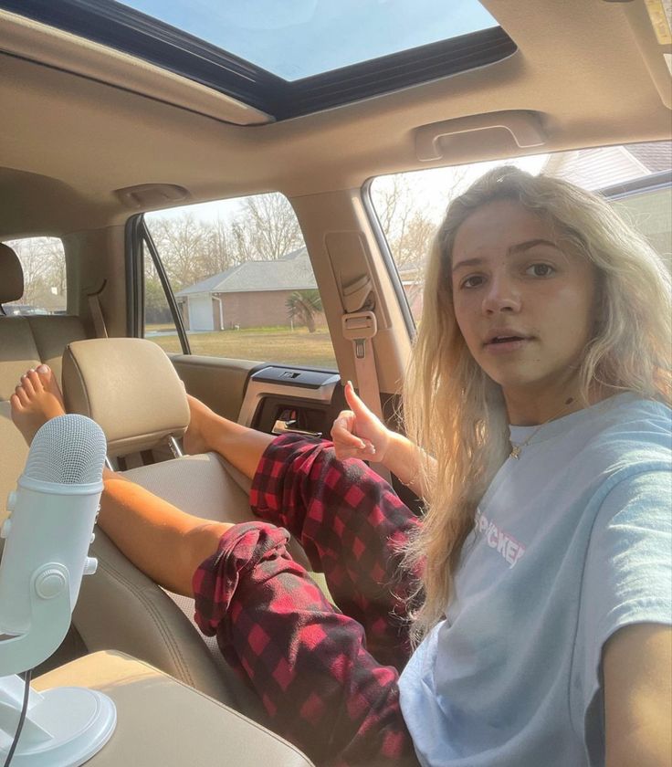 a woman sitting in the driver's seat of a car