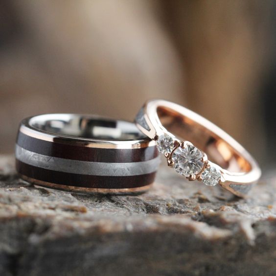 two wedding rings sitting on top of a rock