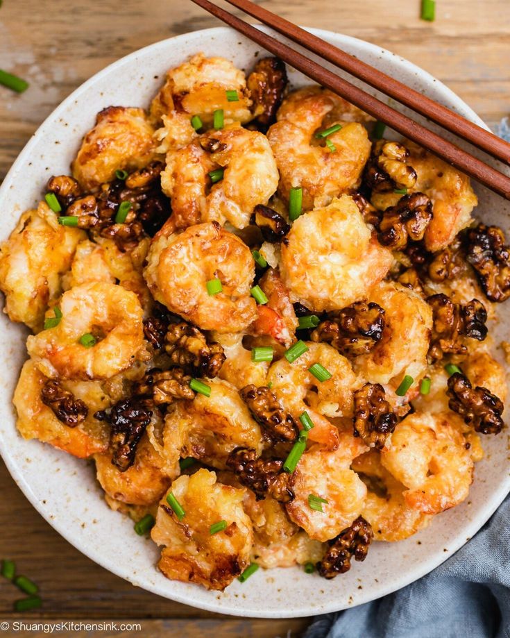 a white bowl filled with fried food and chopsticks