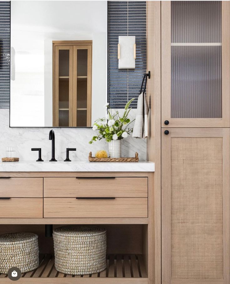 a bathroom with a large mirror and wooden cabinets