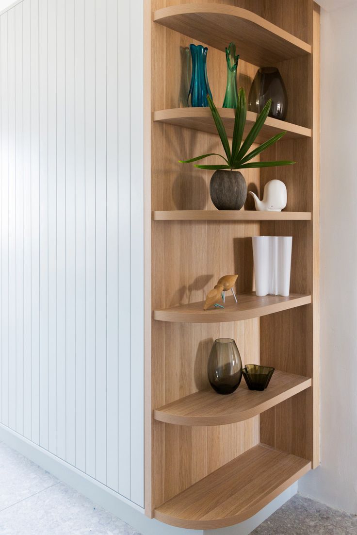 a wooden shelf filled with vases and plants