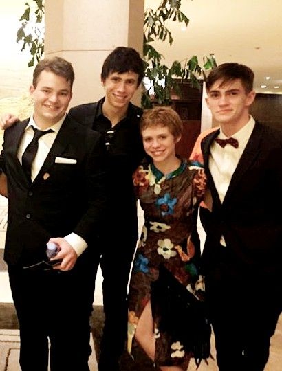 four young men in formal wear posing for the camera