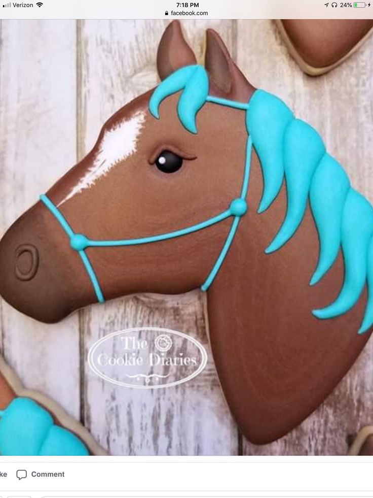 decorated cookies in the shape of horses with blue icing on them and pink frosting on their heads