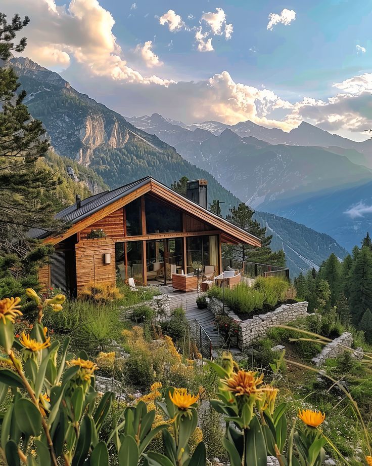 a wooden cabin sitting on top of a lush green hillside covered in flowers and trees