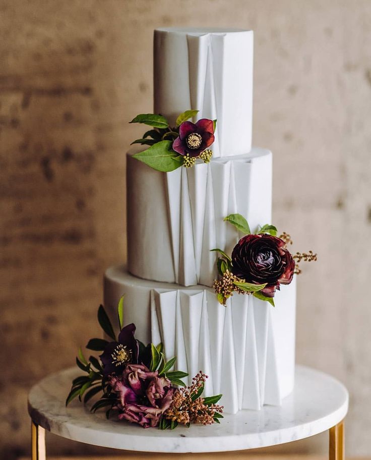 a three tiered white cake with flowers on top