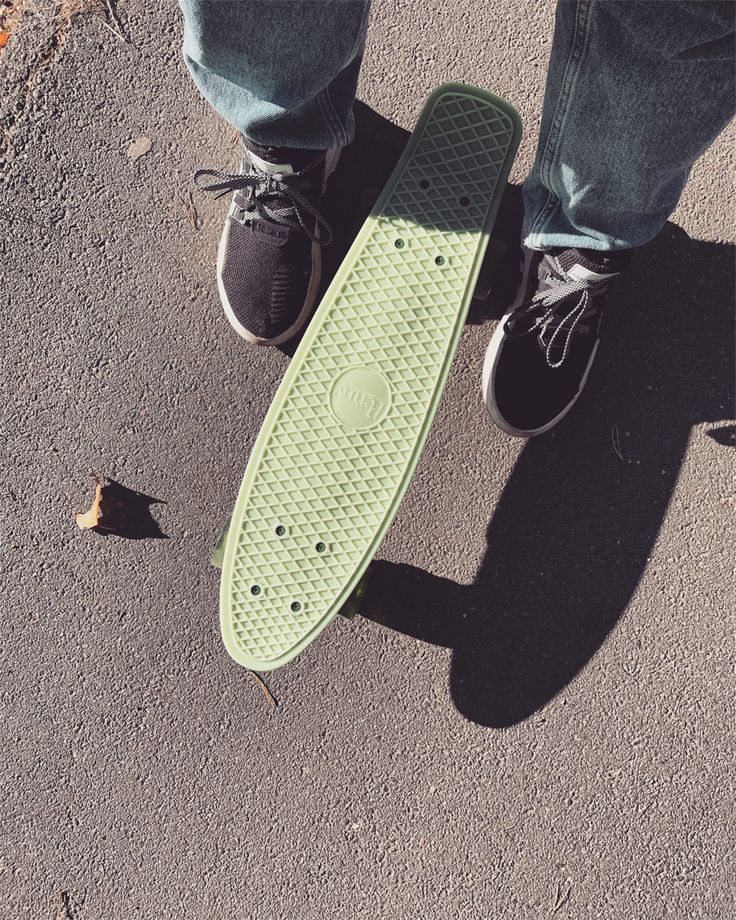 a person standing on top of a green skateboard