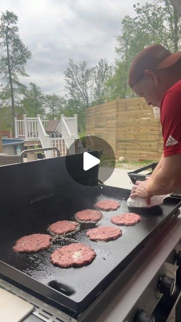 a man cooking hamburgers on an outdoor grill