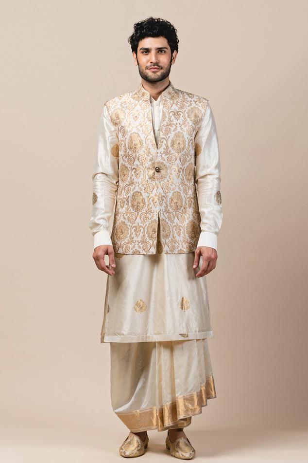 Ivory Nehru jacket with all-over floral motifs and zardozi work. Comes with straight kurta and draped dhoti. 
Component: 3
Embroidered
Neckline: Mandarin Collar
Sleeve Length: Kurta: Full
Fabric: Spun Silk, Chanderi, Brocade
Color: White
Cuff sleeves
Draped dhoti
Closure: Bundi: Front buttons - Aza Fashions Gents Kurta, Nehru Jacket, Silk Kurta, Tarun Tahiliani, Nehru Jackets, Embroidered Neckline, Indian Fashion Designers, Silk Brocade, Kurta Designs