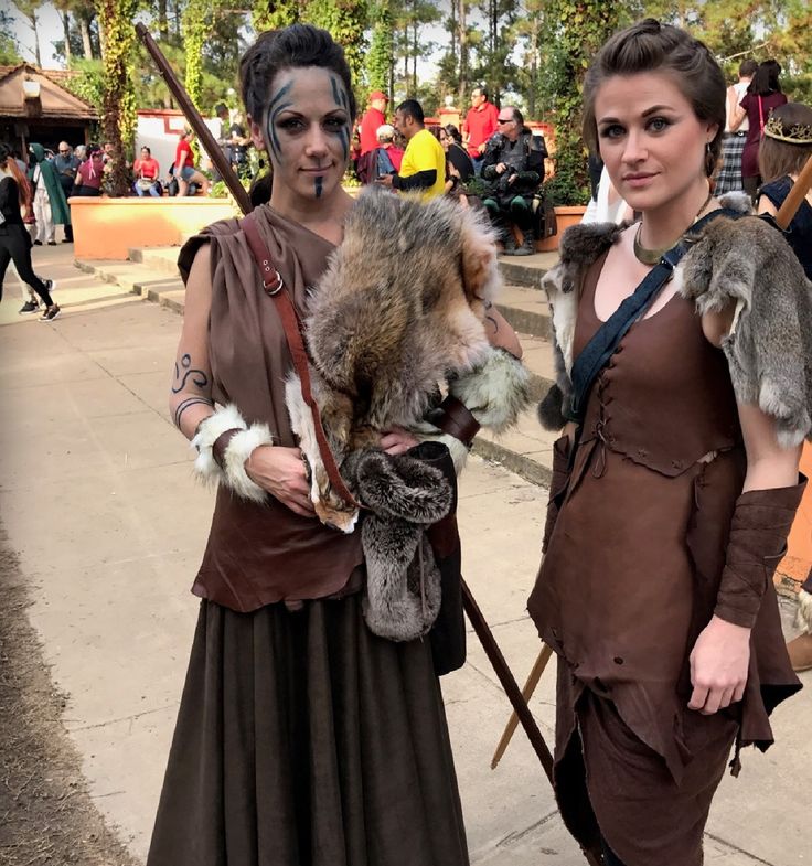 two women dressed in costumes standing next to each other