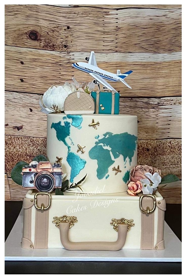 a cake decorated with an airplane, suitcases and other things on top of it