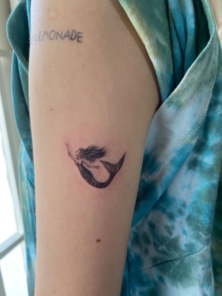 minimal tattoo ideas Siren Tattoo Ideas For Women, Mermaid In Shell Tattoo, Mermaid Line Art Tattoo, Mermaid Tattoo Aesthetic, Simple Mermaid Tattoo Ideas For Women, Mermaid Aesthetic Tattoo, Mermaid Ankle Tattoo, Tattoo Ideas Mermaid, Mermaid Tattoo Minimalist