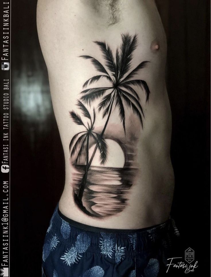 a man with a palm tree tattoo on his chest is standing in front of the ocean