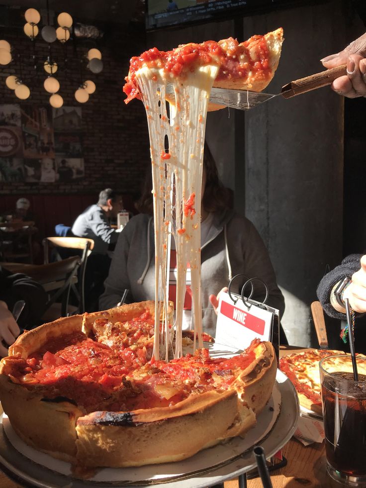 a deep dish pizza being served at a restaurant