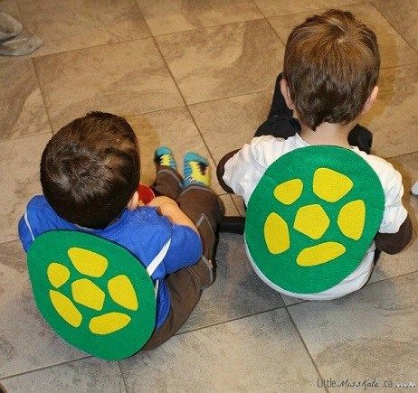 two boys sitting on the floor with their costumes