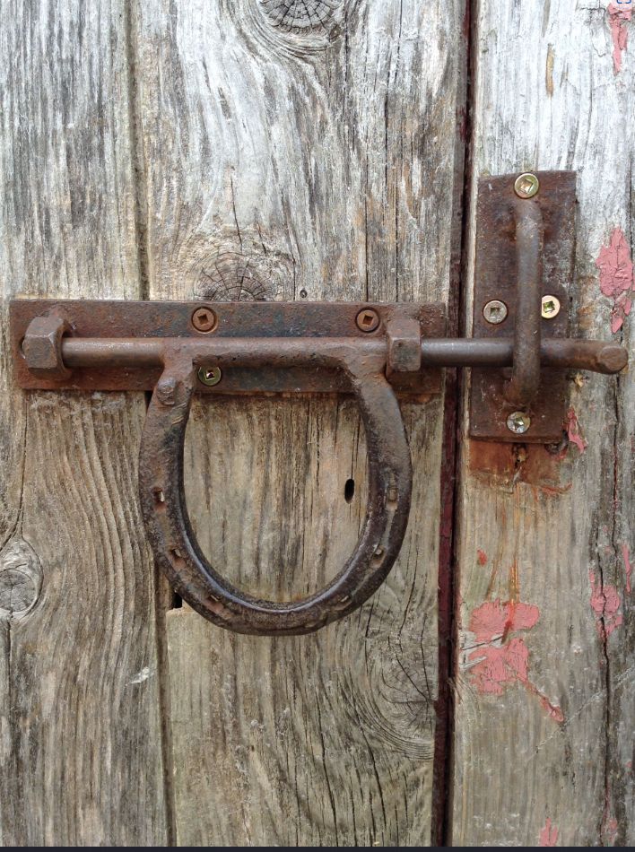 an old rusted metal door handle on a wooden door