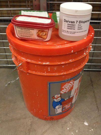 an orange trash can with two containers on top