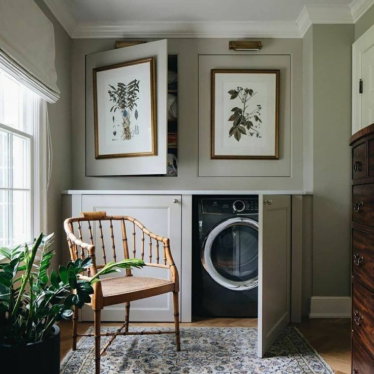 a washer and dryer in a room with pictures on the wall above it