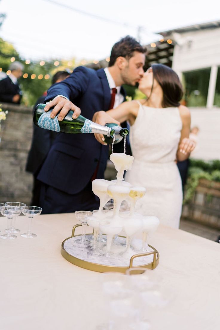 a bride and groom are pouring champagne into glasses