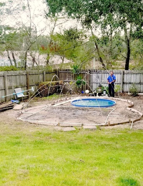 a man standing next to a pool in a yard