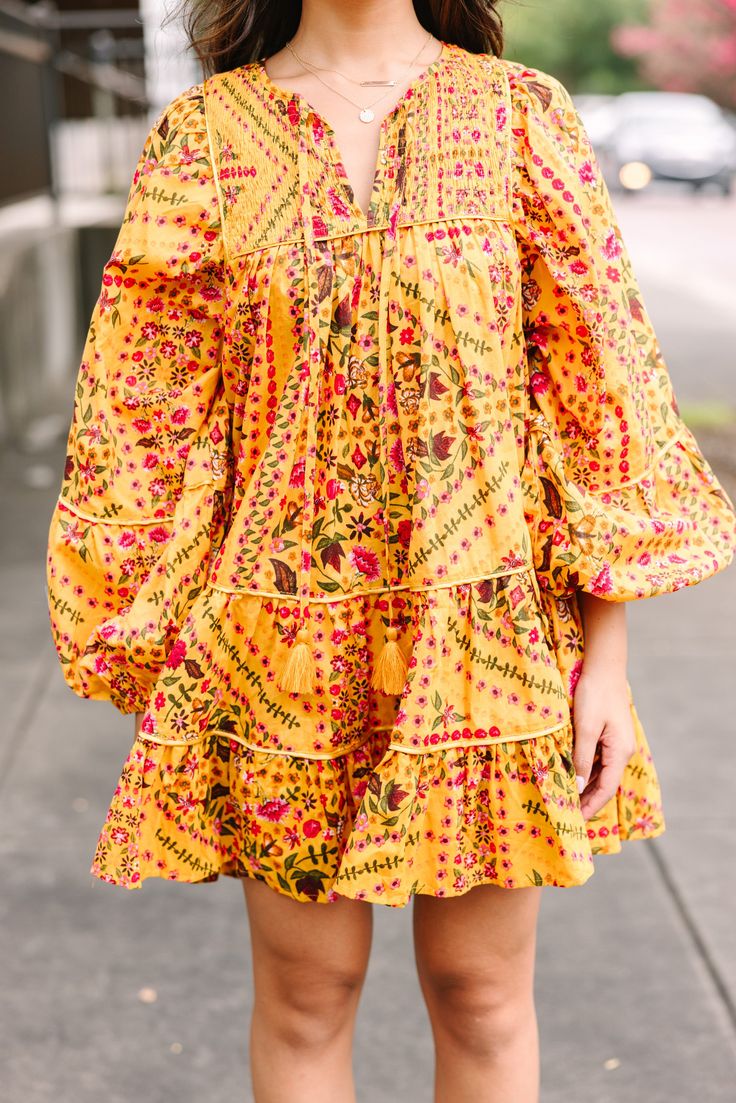 Officially obsessed! This dress is so eye catching! That floral print is so unique and we are loving the color combo! This flowy babydoll dress is perfect for now through fall! V-neckline with tied details Long bubble sleeves Babydoll fit Unique floral print No stretch Cindy is wearing the small. Printed Floral Dress For Fall Vacation, Printed Dress For Fall Brunch, Multicolor Bohemian Floral Dress For Fall, Fall Bohemian Mini Dress For Brunch, Bohemian Mini Dress For Fall Brunch, Yellow Printed Fall Dress, Yellow Mini Dress For Fall Vacation, Yellow Bohemian Flowy Mini Dress, Yellow Flowy Bohemian Mini Dress