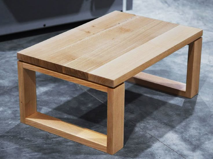 a wooden table sitting on top of a cement floor