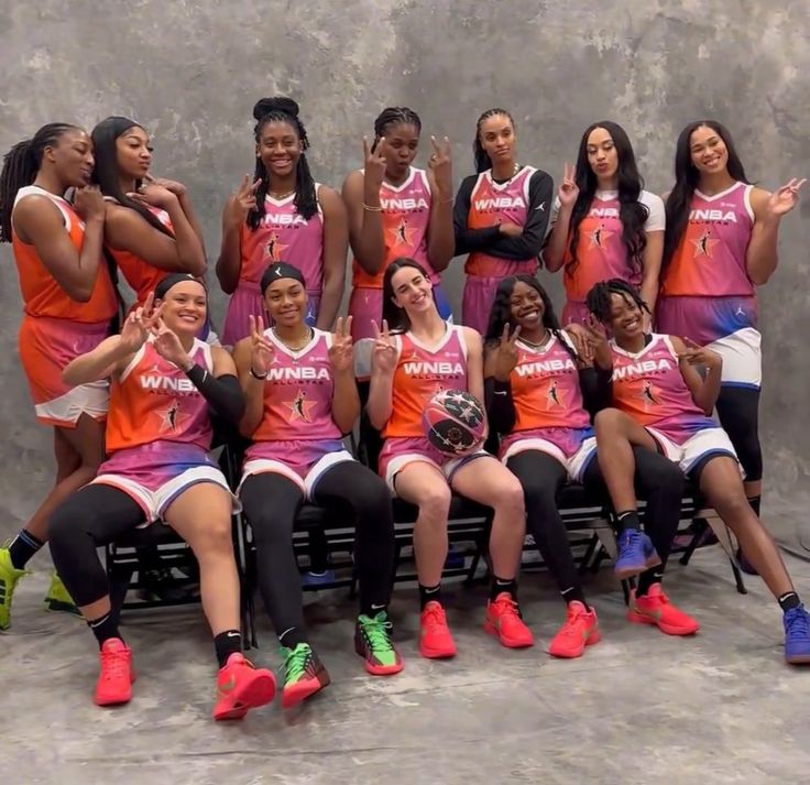 the women's basketball team is posing for a photo in their pink and orange uniforms