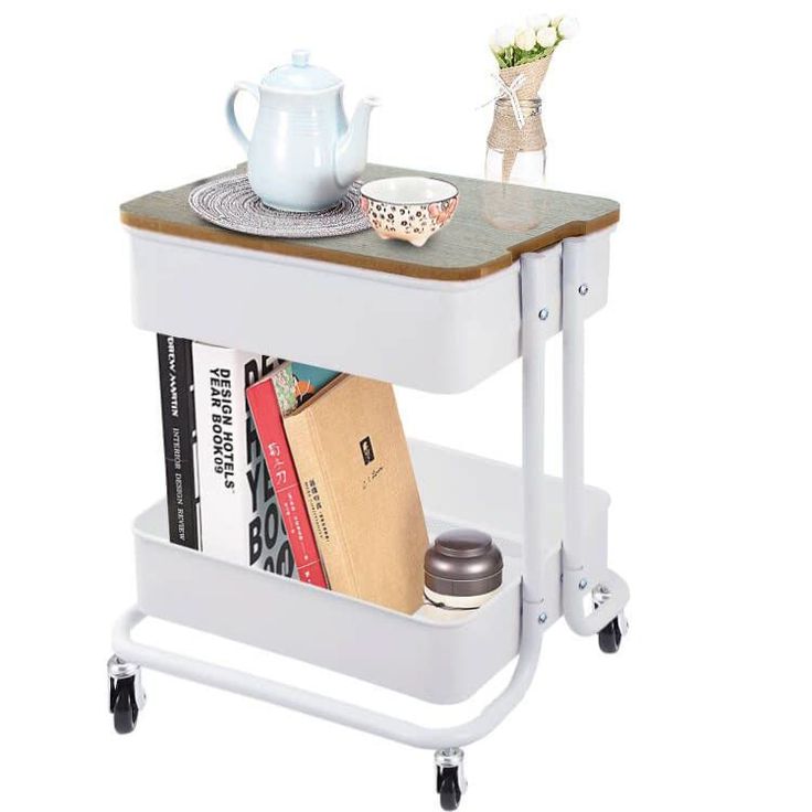 a table with a book shelf on wheels and a tea pot sitting on top of it