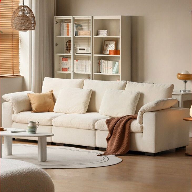 a living room filled with furniture and bookshelves next to a white rug on top of a hard wood floor